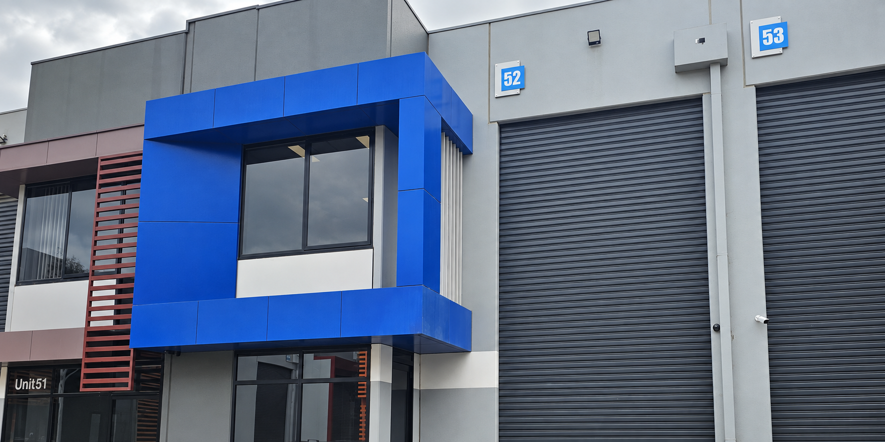 Commercial property with blue office frontage and roller doors